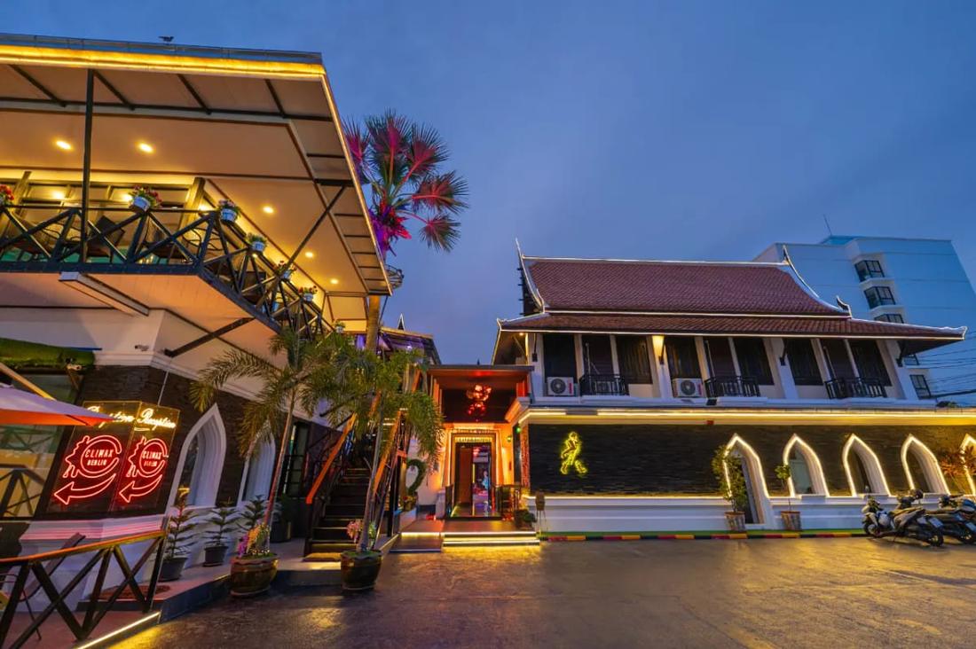 The lit entrance and Thai-style pavilion of Climax Berlin in Na Kluea at dusk