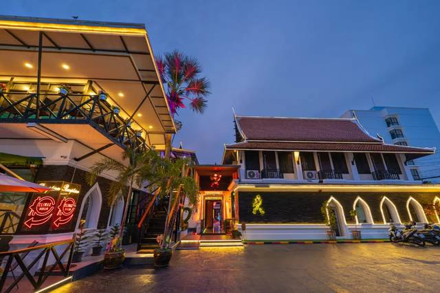 The lit entrance and Thai-style pavilion of Climax Berlin in Na Kluea at dusk